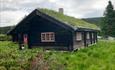 Einen Blockhaus an dem Gammelskolla Alm.