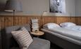 Double room with made double bed. Comfy chair and cozy interior. Spidsbergseter Resort Rondane.