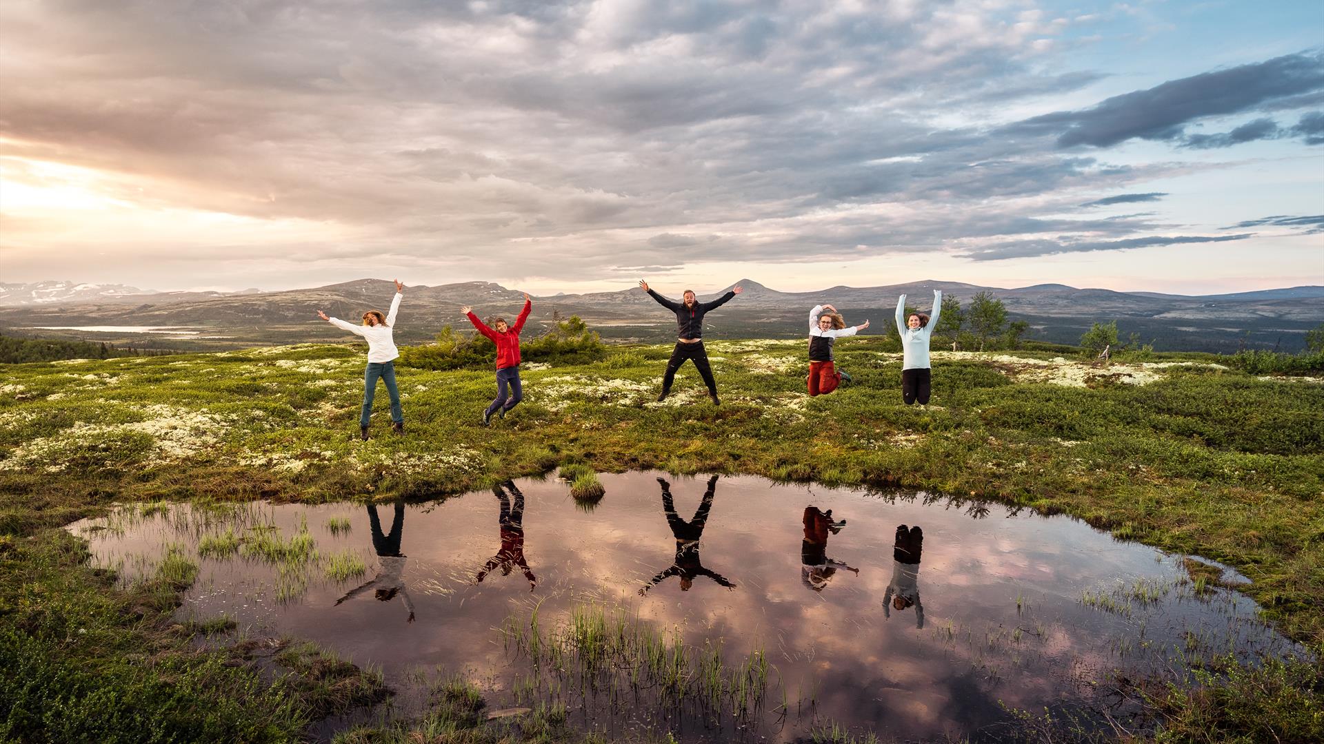 Group of hikers jumping by the water | Venabu Fjellhotell