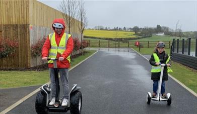 Image of adult and child on segway