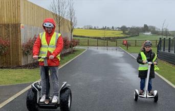 Image of adult and child on segway