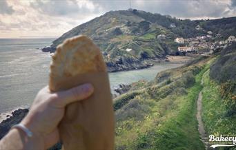 Polperro Bakery - pasty with a background view of Polperro