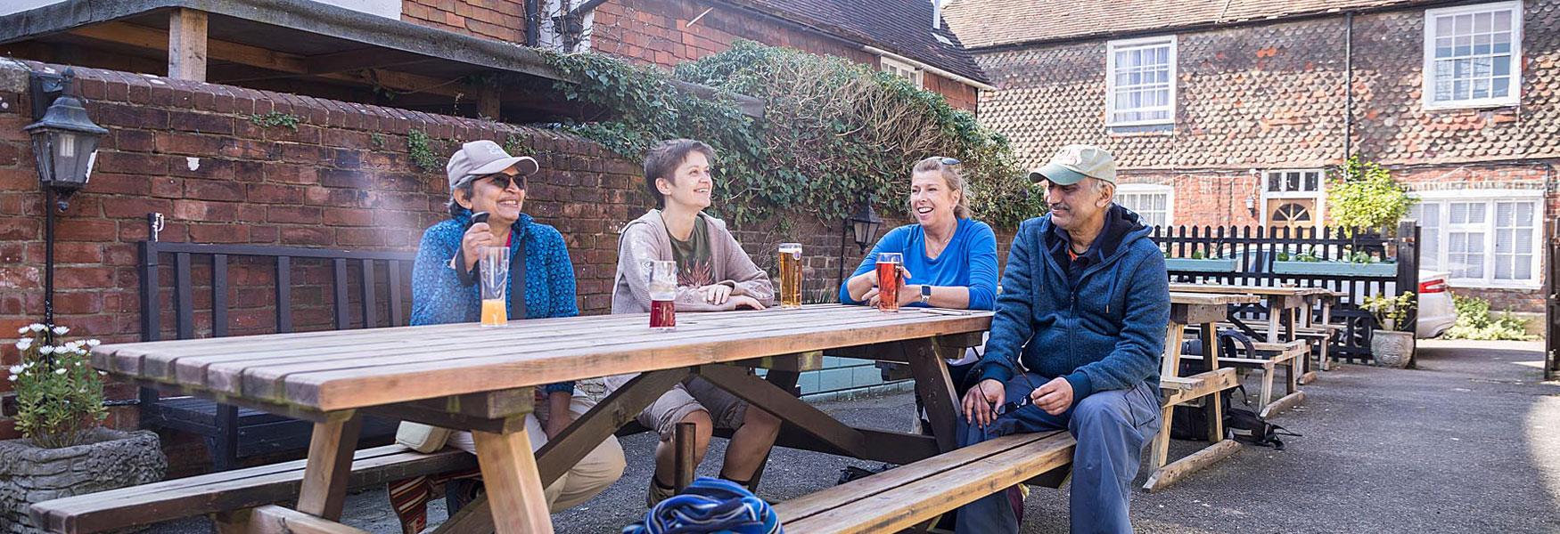 Walkers  sitting enjoying a drink outside a pub