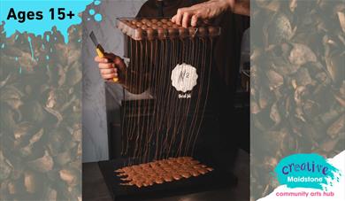 Hand holding a tray of chocolate truffles upside down with molten chocolate running out and pooling on a dark counter top