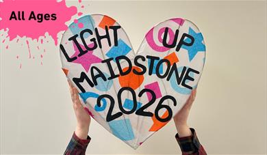 Paint Splat with All ages in the top left-hand corner. Main Image 2 hands holding up a heart-shaped Willow Lantern covered in colourful shapes with th