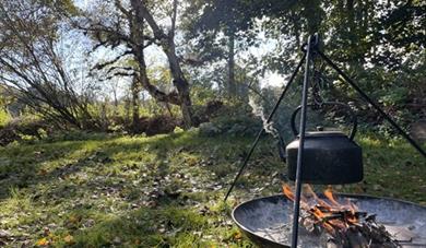 A campfire with kettle hanging over the fire