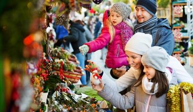 Family looking at Christmas decorations at a fair.