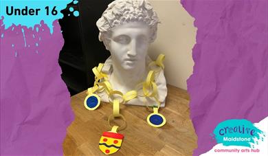 A classical sculpture of a head wearing a paper mayoral chain