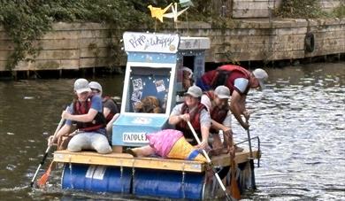 A raft made of oil cartons with people paddling 