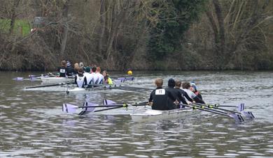 Three four-crew rowing boats competing on the River Medway
