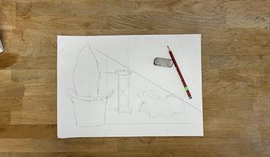 A sheet of white paper with a pencil and rubber on the side of the paper. on the paper is a pencil drawing of a plant, hourglass and shell 