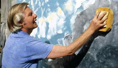 Artist Tony Hart using a sponge to create a large-scale artwork