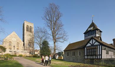 A group of people in Brenchley Gardens, Maidstone with the museum and St Faith's Church