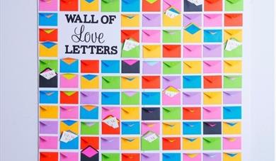 A square of colourful envelopes some with notes peeking out