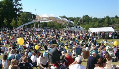 Whatman Park during a concert with many groups of people sitting in the sunshine