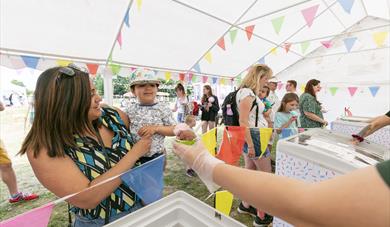 Woman handing over ice cream to child at Kent Life's Ice Cream Festival 2023