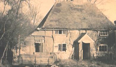photo of Kettlebender Farm in Waltham parish, showing a dilapidated farm house with a four wheeled cart in the foreground