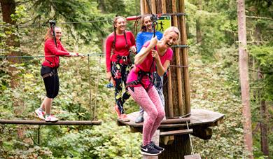 Woman laughing with friends on high ropes