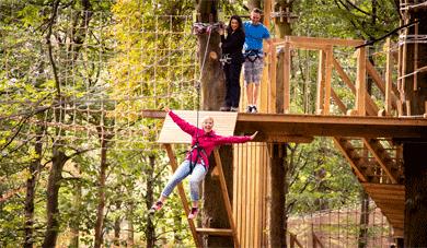 Woman on zip wire in the woods.