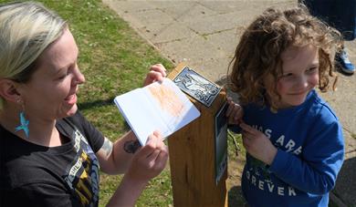 Child enjoying the wax rubbings on the plaque