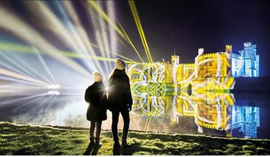 Children looking at Leeds Castle illuminated for Christmas