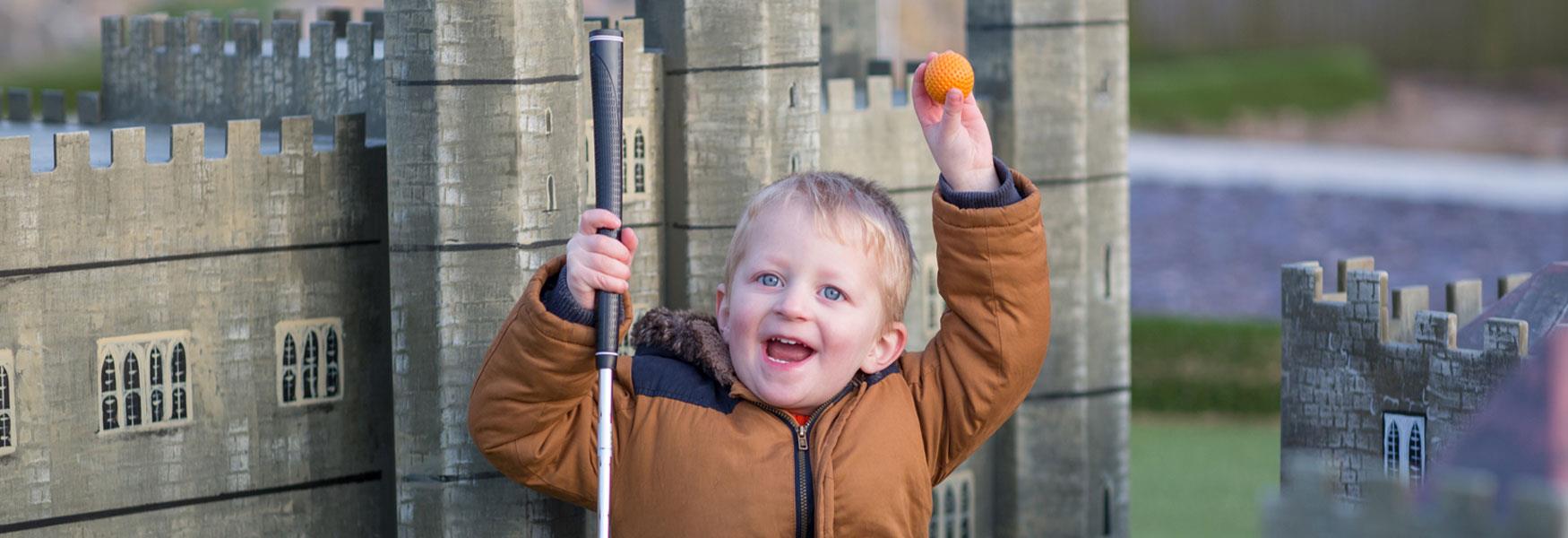 Little boy smiling at Leeds Castle adventure golf.