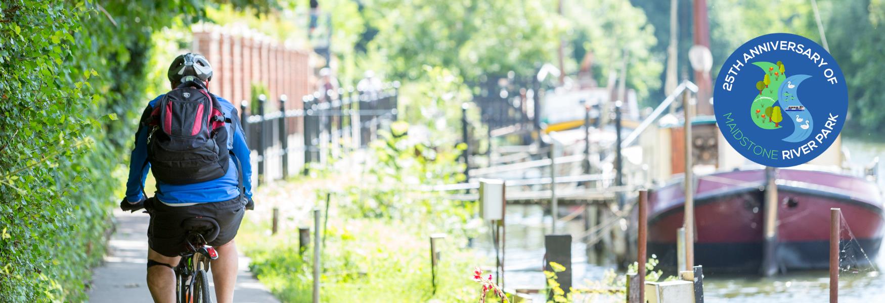 Cyclist enjoying the Maidstone River Park towpath, alongside the River Medway