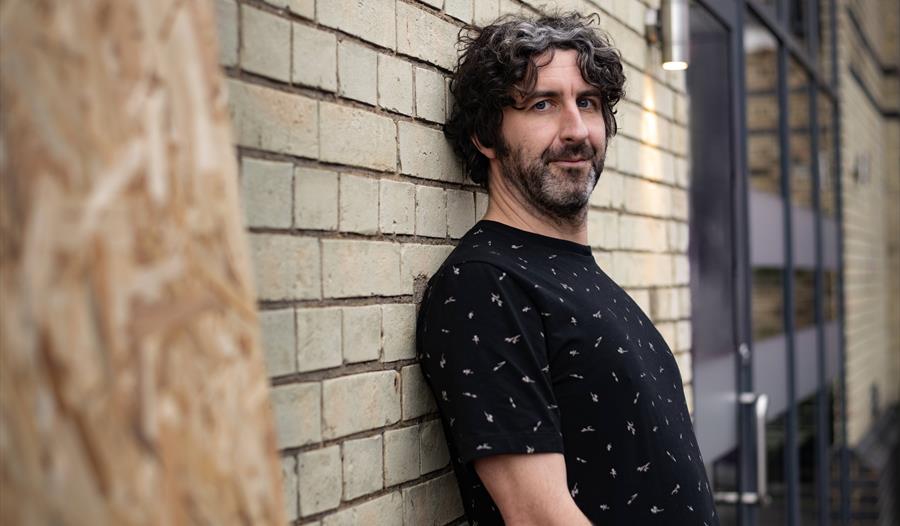 Mark Watson leaning against a wall