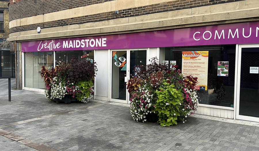 Outside of Creative Maidstone with the large flower containers in bloom