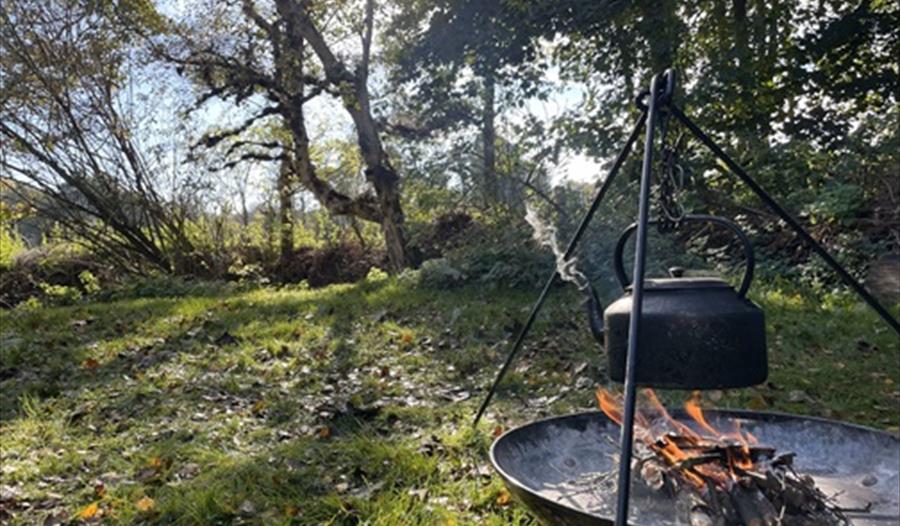A campfire with kettle hanging over the fire