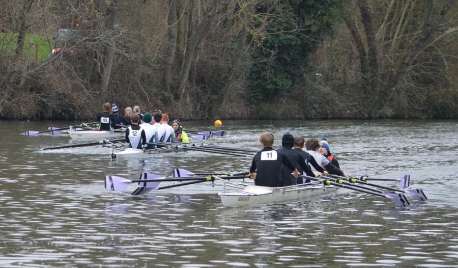 Three four-crew rowing boats competing on the River Medway