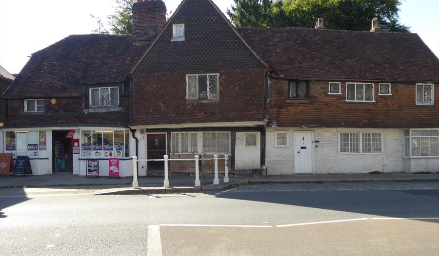 Sepia toned group photograph of Maidstone Swimming Club members, all males in swimming costumes, standing, kneeling or sitting in five rows, a life-fl