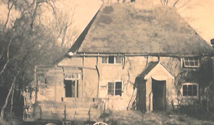 photo of Kettlebender Farm in Waltham parish, showing a dilapidated farm house with a four wheeled cart in the foreground