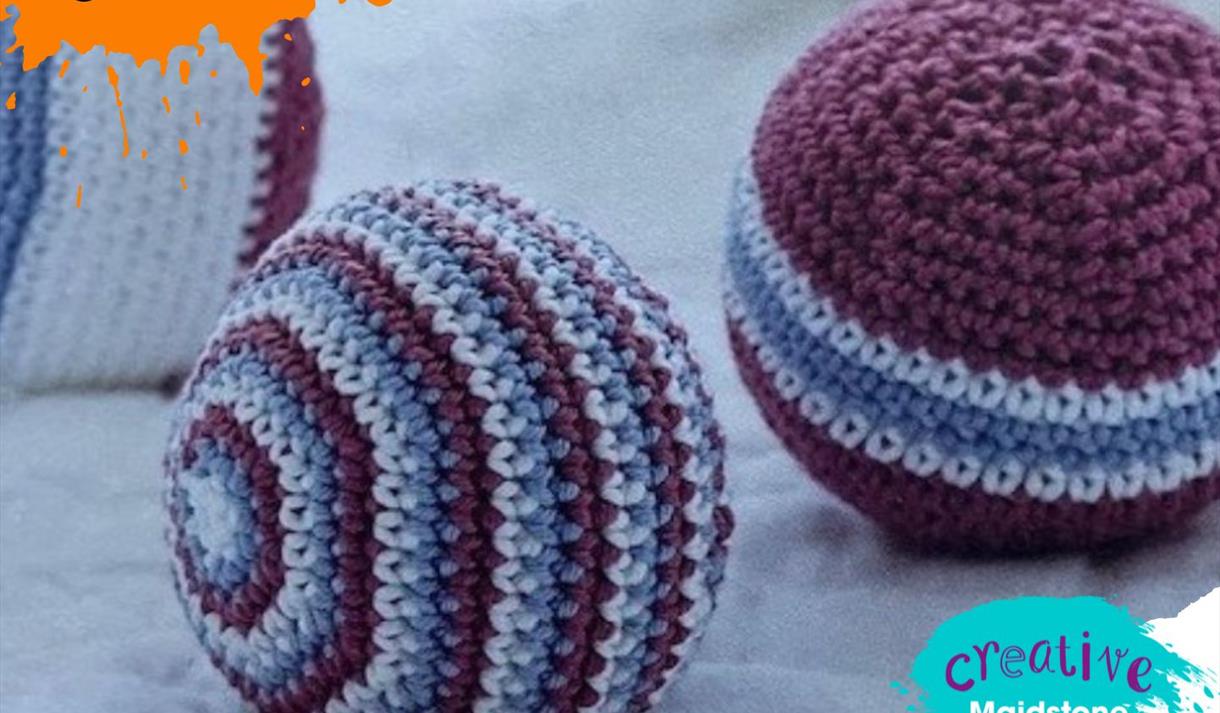Three amigurumi balls on a white blanket