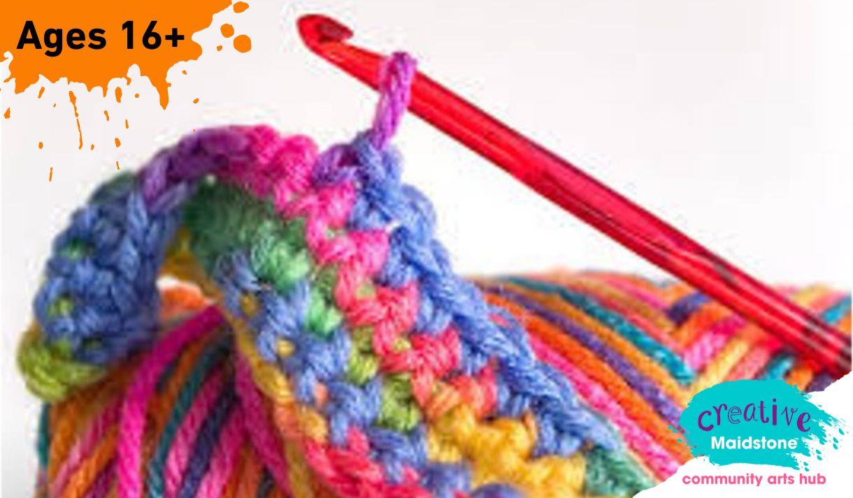 Crochet hook with a brightly coloured ball of yarn and a small piece of crochet work