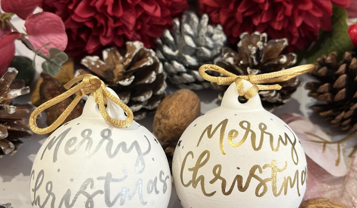 A picture of pretty Christmas baubles with swirly writing on them