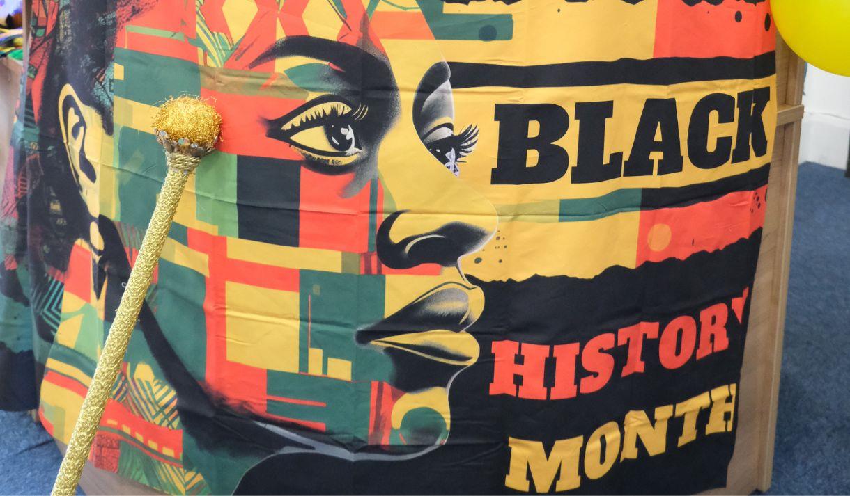 A large drum with a 'black history month' flag draped around the front