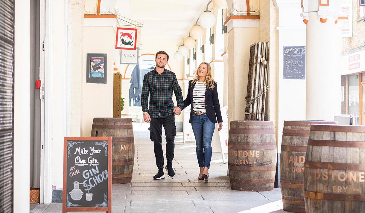 A couple walking through the covered walk way in Market Buildings