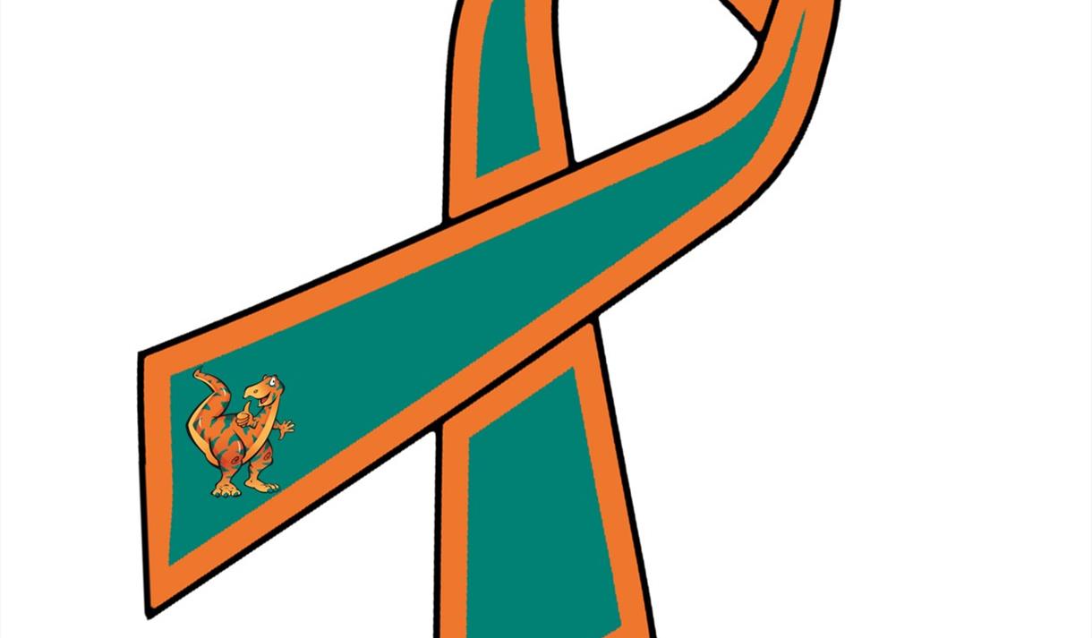 Green and orange ribbon with the ends folded over and a dinosaur on one end