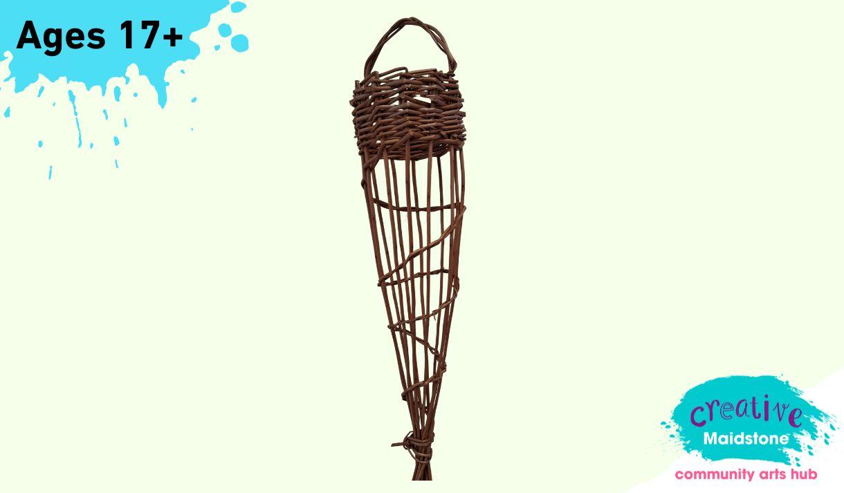 A woven willow bird feeder on a yellow background