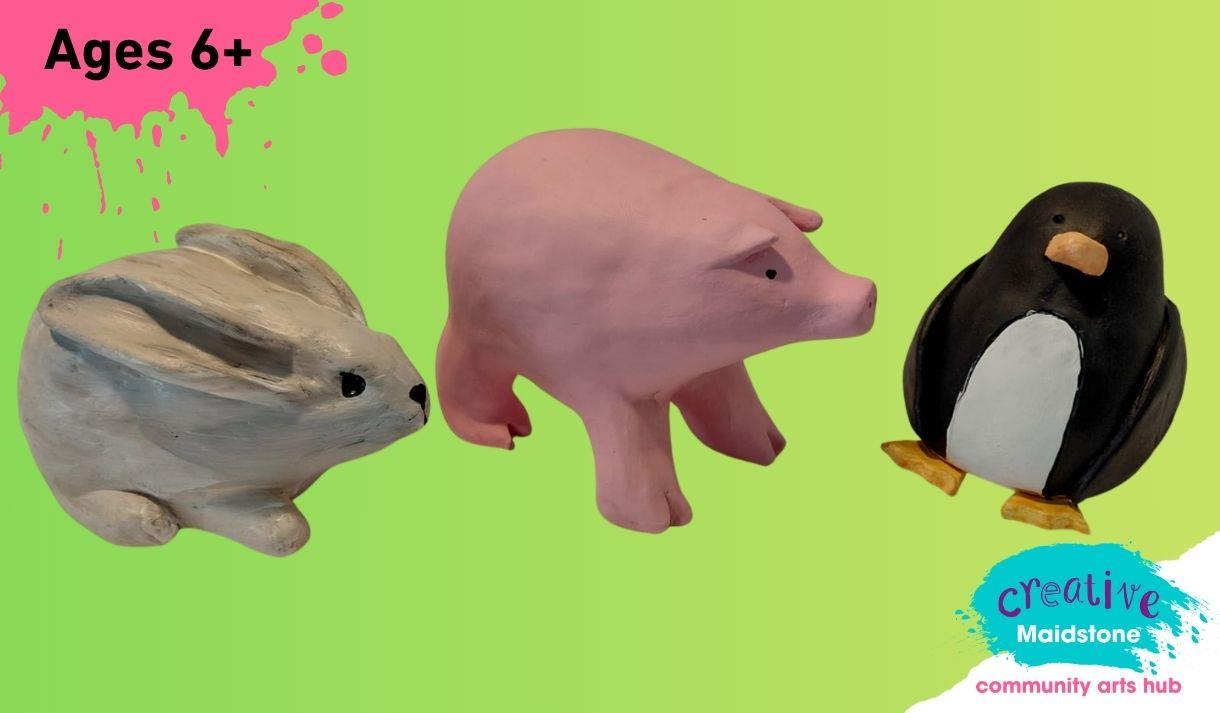 Three pinch pot animals on a green background (rabbit, pig and penguin)
