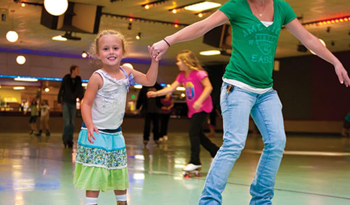 Adult and child enjoying the roller disco