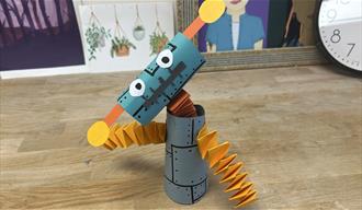 Small paper robot with according arm and a neck with an antennae coming out of each side of the robots head