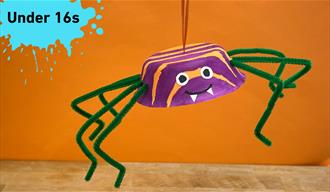 Paint splat in the top left corner with under 16s in black text. Main image an orange and Black spider made from a paper bowl