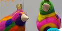 Two brightly coloured needle-felted birds with cardboard beaks and paper crowns