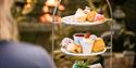 Afternoon tea at the Chilston Park cakes displayed on a 3 tiers stand in front of the fire.