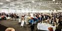 Exhibition hall full of stalls and people browsing