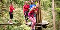 Woman laughing with friends while on high ropes