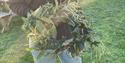 A workshop participant holding a wreath made from willow and seasonal foliage.