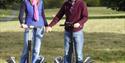 A couple on Segways with Leeds Castle in view